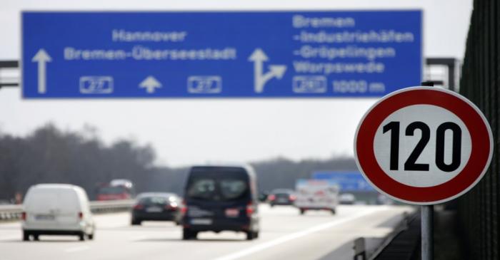 Cars pass a 120 km/h (75 mph) speed limit sign on the A27 Autobahn near the northern German