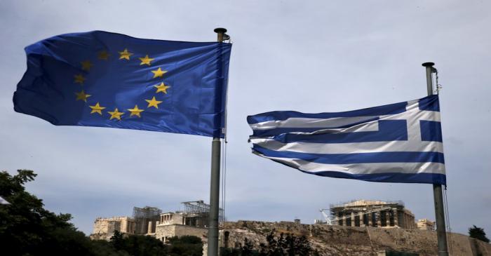 FILE PHOTO: An EU flag and a Greek national flag flutter as the ancient Parthenon temple is