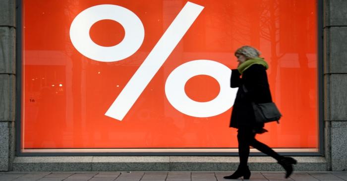 A woman passes a sale sign in a shop window in downtown Hamburg
