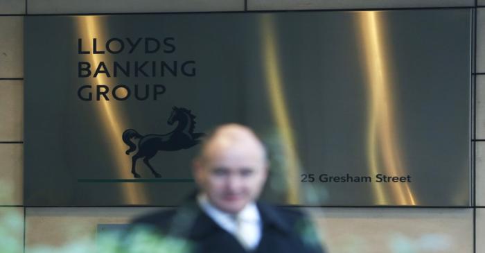 A man walks past the entrance to the head office of Lloyds Banking Group in the City of London