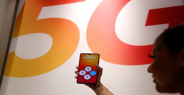 An employee displays a Huawei 5G Smartphone Mate 20X smartphone at a Sunrise telecommunications