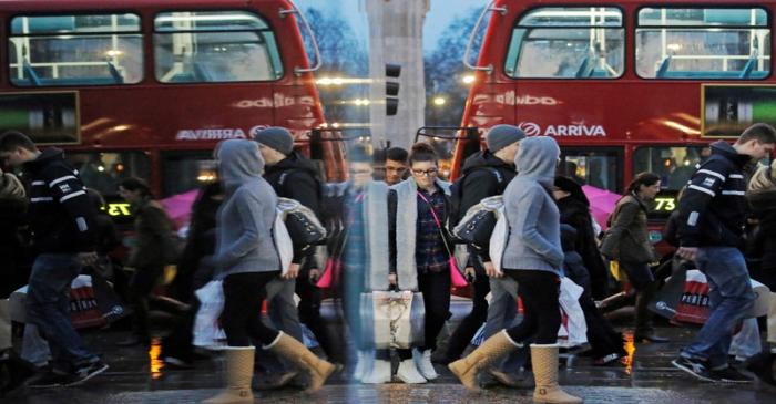 FILE PHOTO: Shoppers are reflected in a shop window as they walk along Oxford Street on the