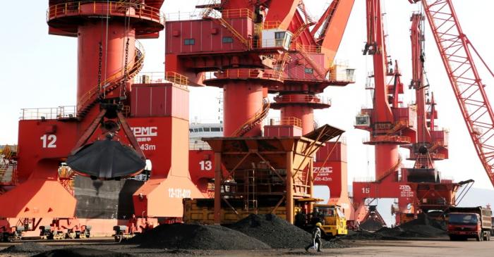 Cranes unload coal from a cargo ship at a port in Lianyungang