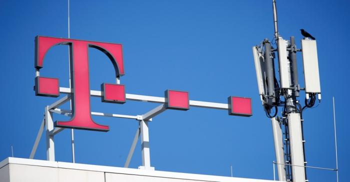Logo of German telecommunications giant Deutsche Telekom AG and GSM and antennas are seen atop