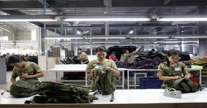 Workers conduct quality checks on their products at a factory owned by Yakeda Outdoor Travel
