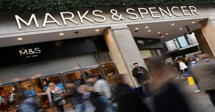 Shoppers walk past a branch of Marks and Spencer in central London, Britain