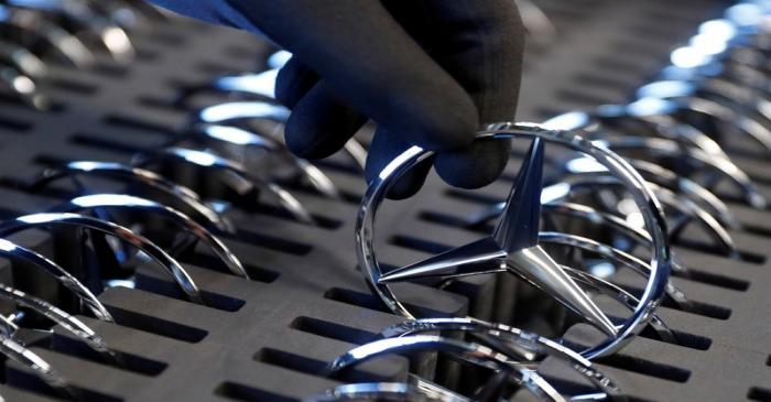 FILE PHOTO: An employee of German car manufacturer Mercedes Benz prepares the company's logo