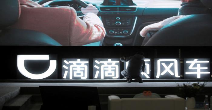 FILE PHOTO: Man is seen in front of a Didi sign before a promotional event of its Hitch service