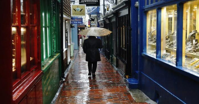 A woman carrying an umbrella walks through 