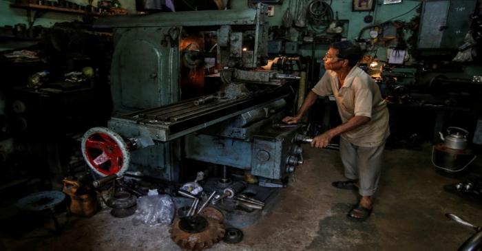 FILE PHOTO: A worker operates a lathe as he makes spare parts of car gearboxes at a workshop in