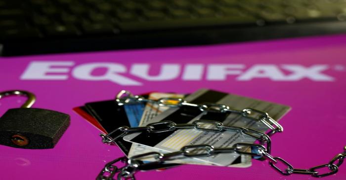 FILE PHOTO: Credit cards, a chain and an open padlock is seen in front of displayed Equifax