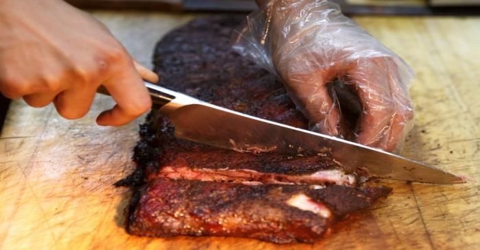 FILE PHOTO: A chef cuts U.S. imported pork ribs that were smoked at the Beijing barbeque