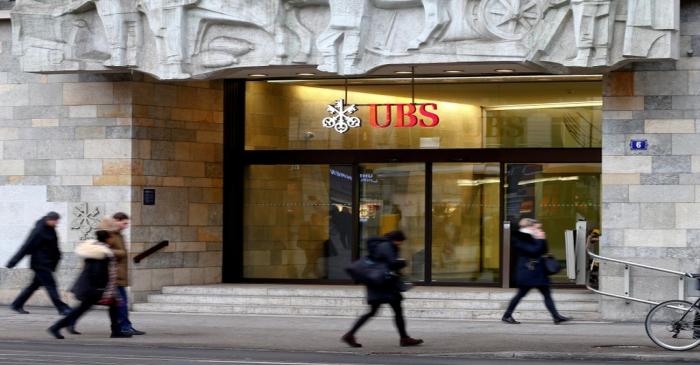 FILE PHOTO: People walk past a branch office of Swiss bank UBS in Zurich