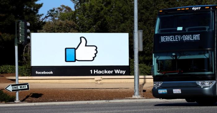 FILE PHOTO: An employee bus is seen next to the entrance sign to Facebook headquarters in Menlo