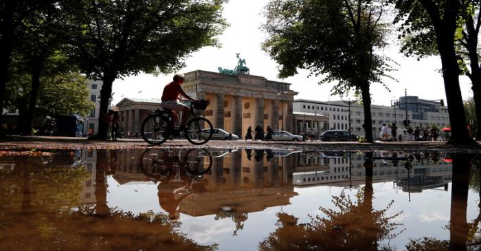 The Brandenburg Gate is reflected in a puddle in Berlin
