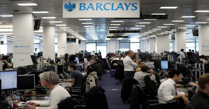FILE PHOTO: Traders work on the trading floor of Barclays Bank at Canary Wharf in London
