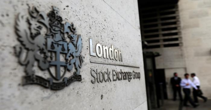 Pedestrians leave and enter the London Stock Exchange in London