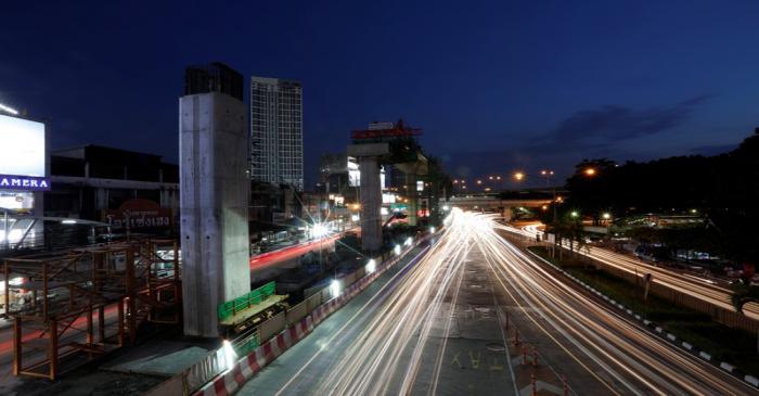 Cars pass Skytrain construction site in Bangkok