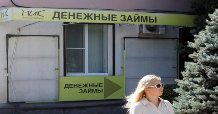 A woman walks past an office of a local lending agency in Stavropol