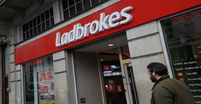 FILE PHOTO: A pedestrian walks past a branch of Ladbrokes in London