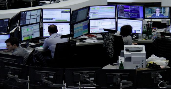 Traders work at their desks at the stock exchange in Frankfurt