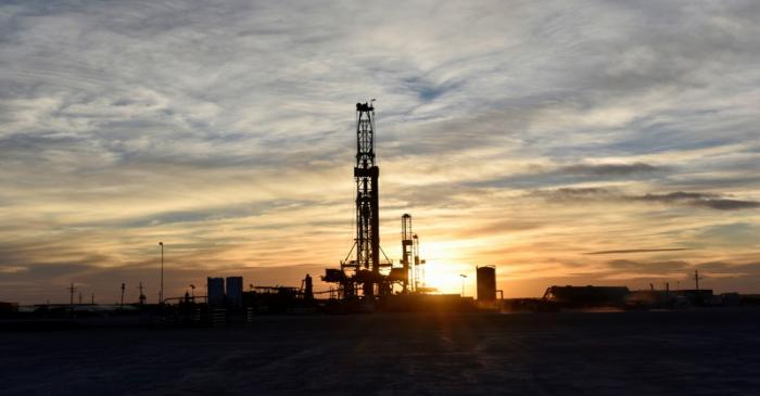 FILE PHOTO: Drilling rigs operate at sunset in Midland, Texas