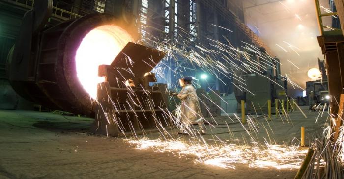 FILE PHOTO - A worker cleans an industrial container for molten steel at the ArcelorMittal
