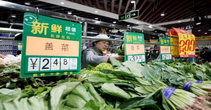 FILE PHOTO: A woman selects vegetables at a supermarket in Beijing