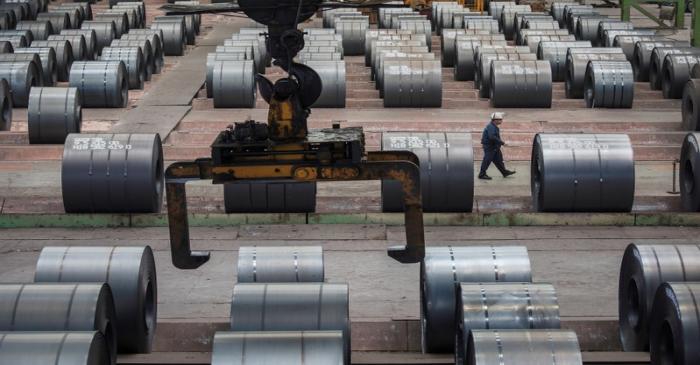 Worker walks past steel rolls at the Chongqing Iron and Steel plant in Changshou