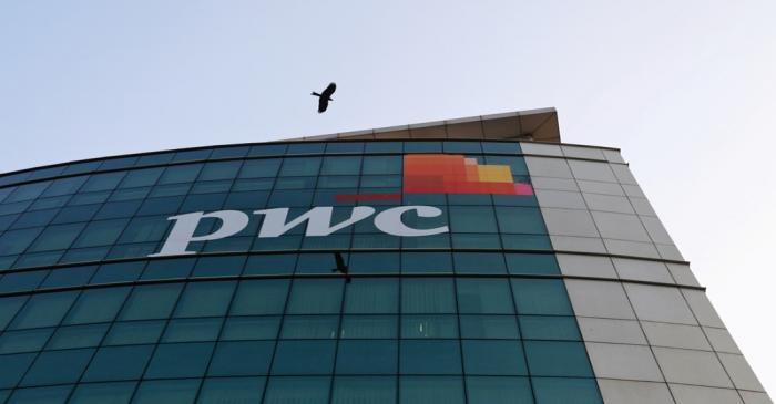 FILE PHOTO: A bird flies past the logo of Price Waterhouse installed on the facade of its