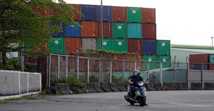 A man rides a motorbike near Kaohsiung Port