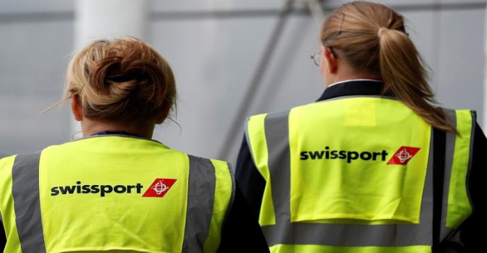 Swissport airport workers  walk across the tarmac at  Liverpool John Lennon Airport in