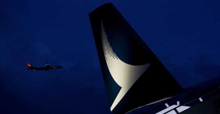 FILE PHOTO: Plane flies behind a new Cathay Pacific Airways Airbus A350 after being received by