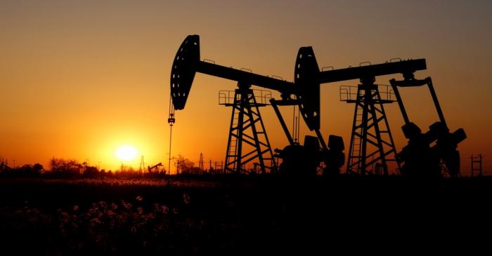 FILE PHOTO:  Pumpjacks are seen against the setting sun at the Daqing oil field in Heilongjiang