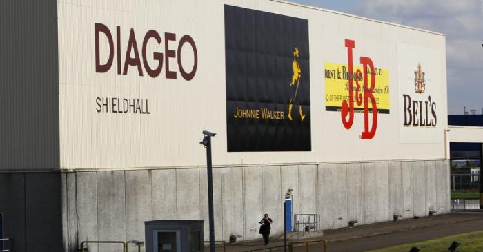 FILE PHOTO - A man walks past a building in the Diageo Shieldhall facility near Glasgow,