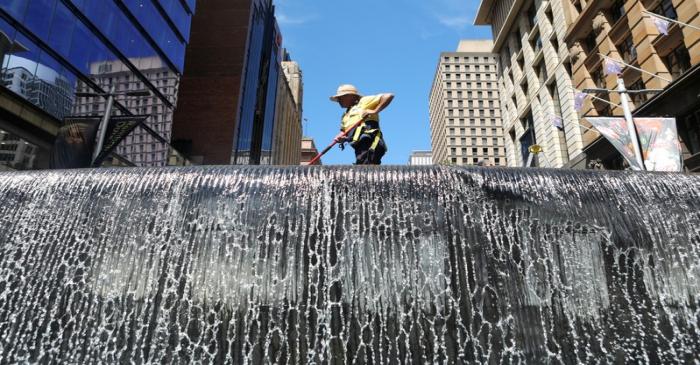 A worker cleans up a water fountain in Sydney's central business district