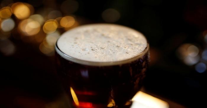 A pint of beer stands on a bar in a pub in Liverpool, northern England