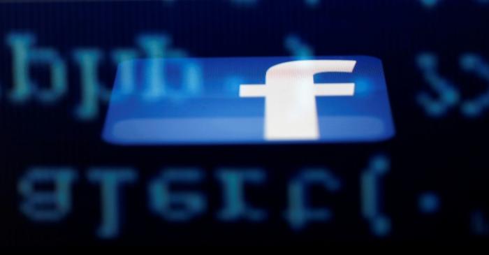 FILE PHOTO: A Facebook logo on an Ipad is reflected among source code on the LCD screen of a