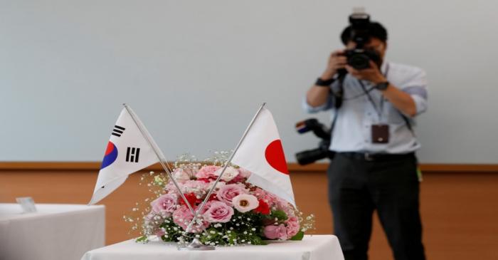 FILE PHOTO: National flags of South Korea and Japan are displayed during a meeting between