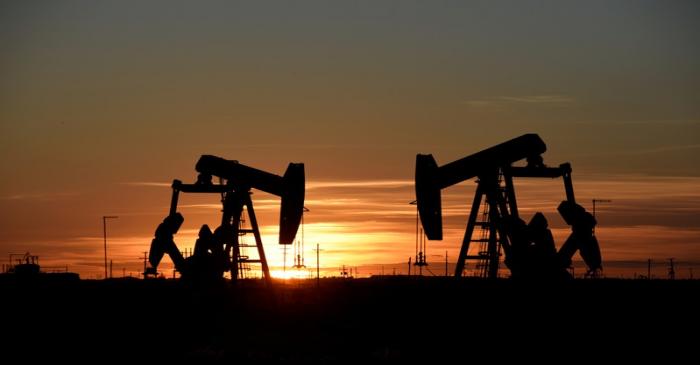 Pump jacks operate at sunset in an oil field in Midland, Texas