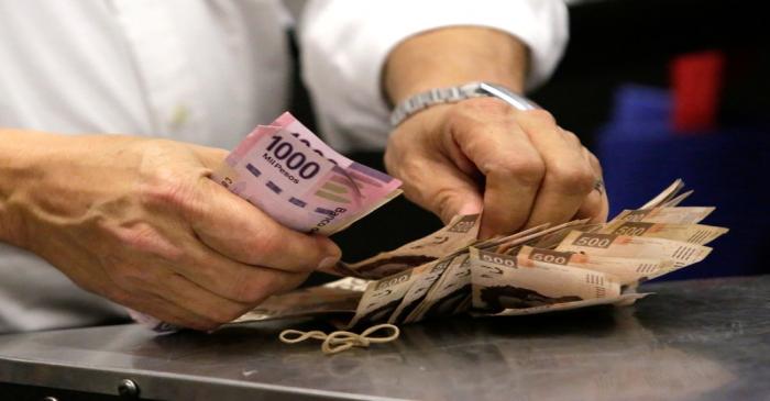 FILE PHOTO: Shopper counts banknotes while paying a TV during the kick-off of the 'El Buen Fin'
