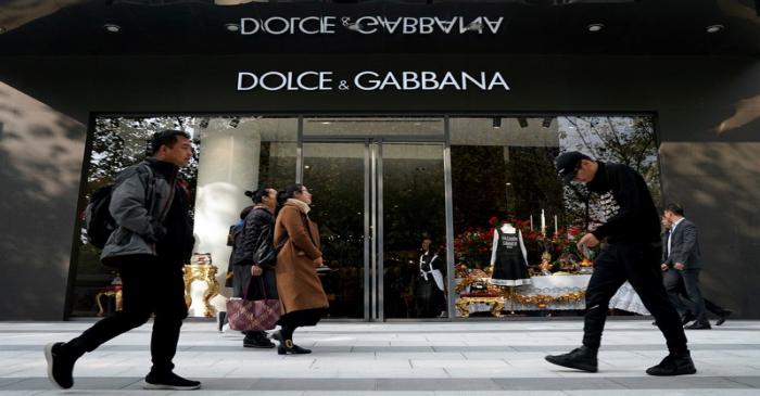 People walk past a Dolce & Gabbana store at a shopping complex in Shanghai