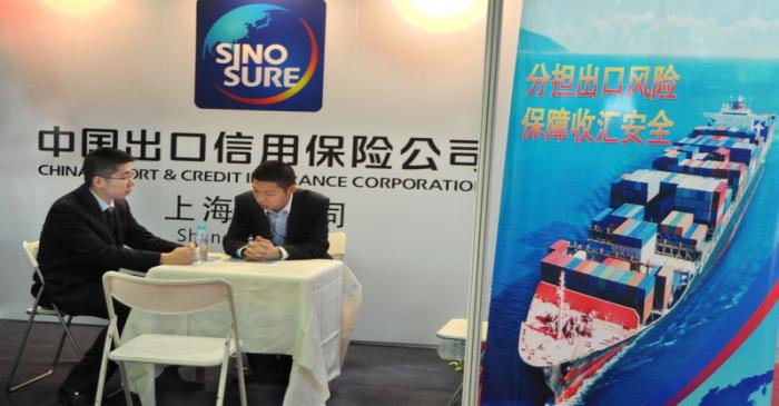 Men sit at a Sinosure booth at the East China Fair in Shanghai