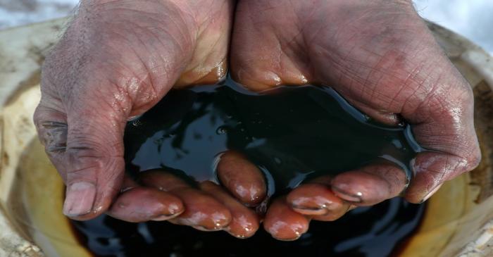 FILE PHOTO: An employee shows a sample of crude oil in the Irkutsk Oil Company-owned Yarakta