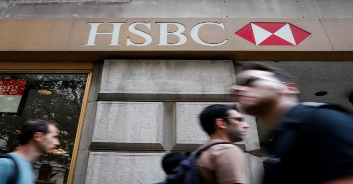 People pass by an HSBC branch bank in the financial district in New York