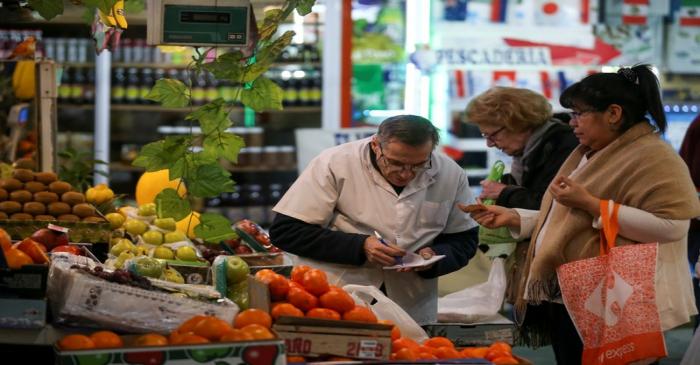 A woman shops in a greengrocery at a local market, in Buenos Aires