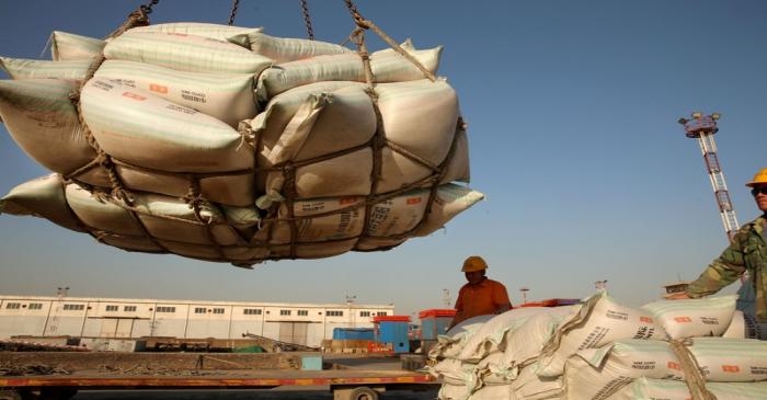 FILE PHOTO: Workers transport imported soybean products at a port in Nantong