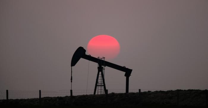 The sun sets behind a pump-jack outside Saint-Fiacre