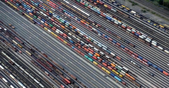 Containers and cars are loaded on freight trains at the railroad shunting yard in Maschen near