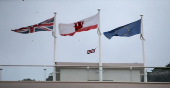 The Union Jack, the Gibraltarian flags and the European Union flag are seen flying in the